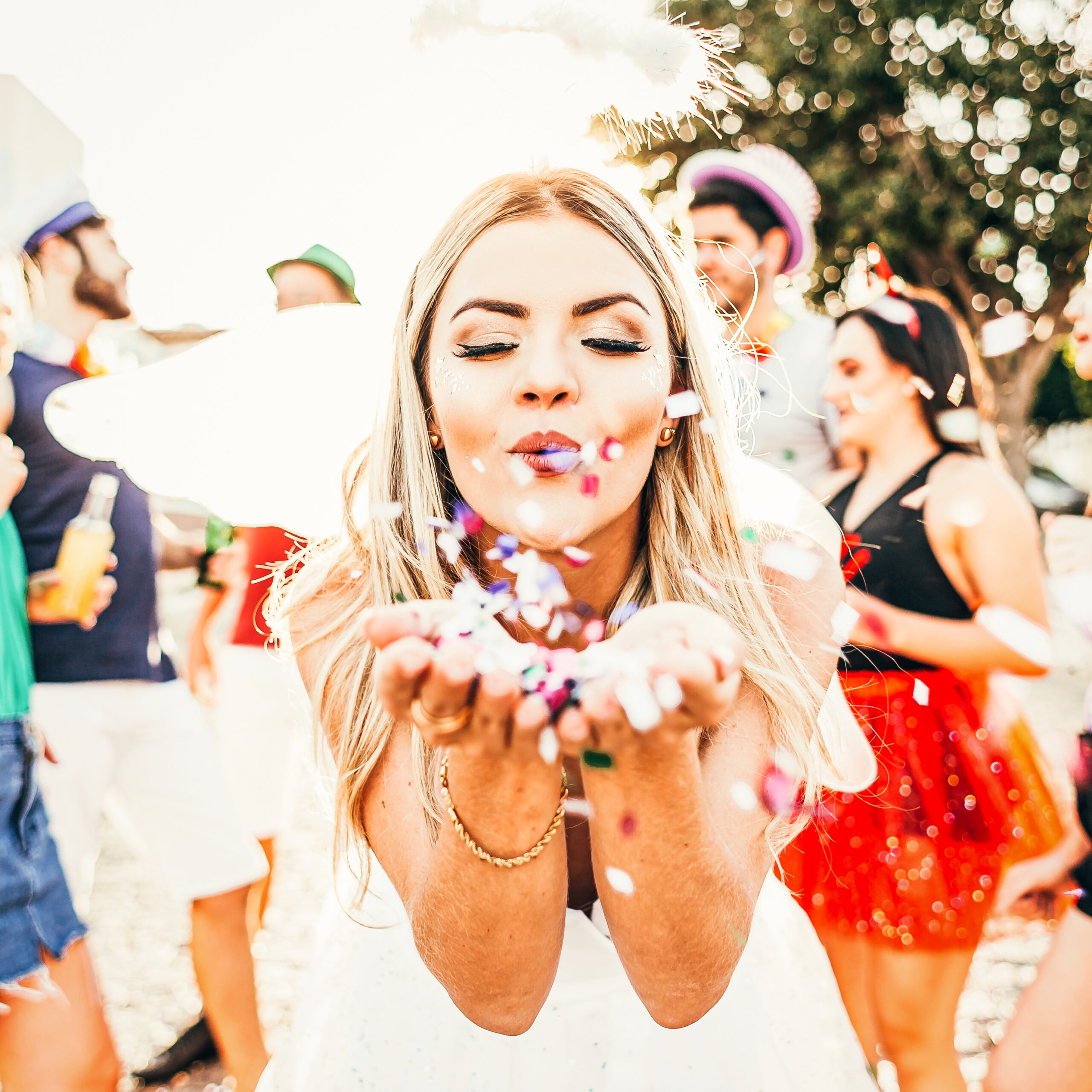 Brazilian Carnival. Young woman in costume enjoying the carnival party blowing confetti